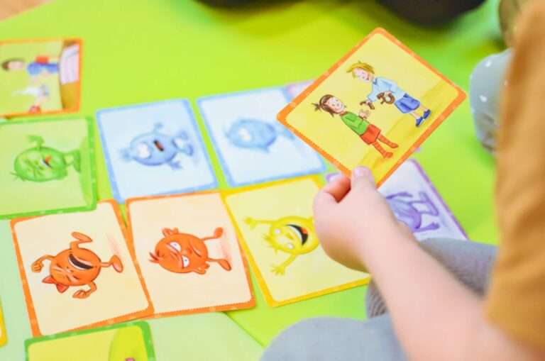 Ein Kind hält eine Bildkarte über ausgelegte Spielkarten