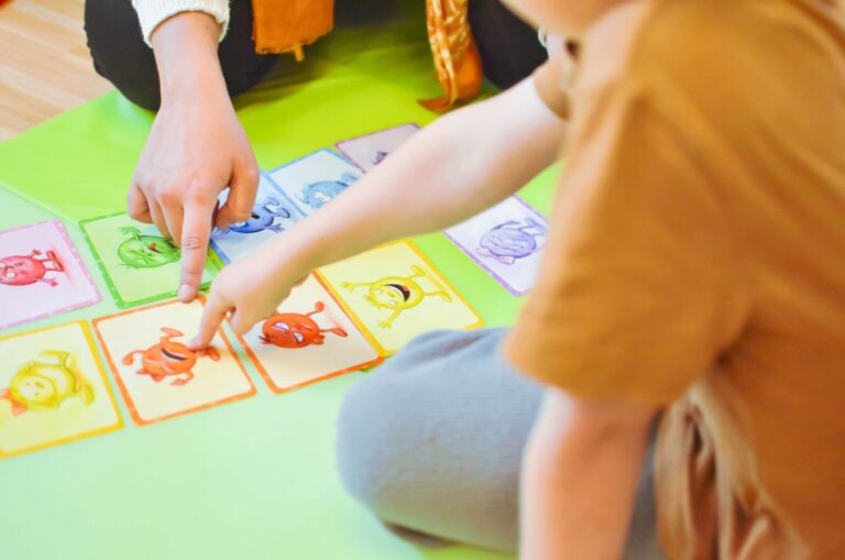 Finger zeigen auf ausgelegte Bildkarten