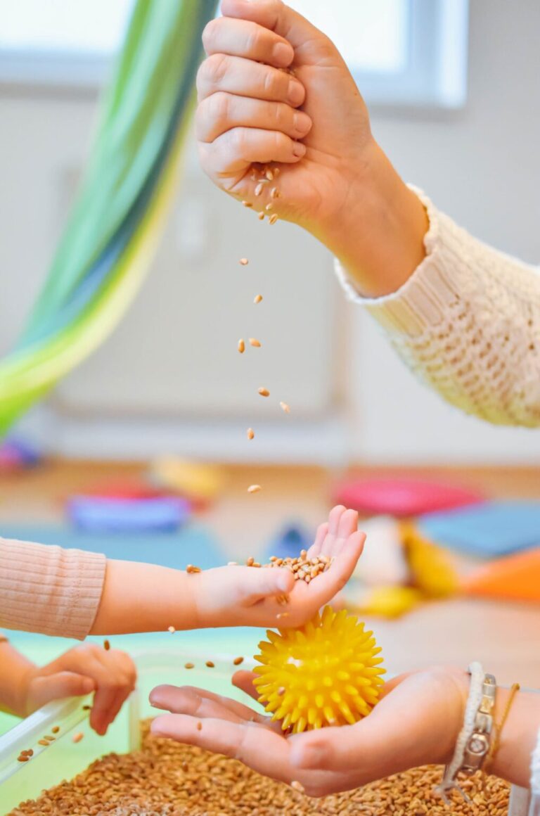Weizenkörner rieseln aus einer Hand in eine Kinderhand